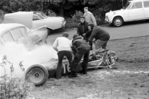 Accident Gallery: Formula One World Championship: A cigarette wielding fire marshal douses the Cooper T86B of Brian