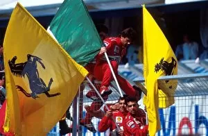 Formula One World Championship: Ferrari mechanics with flags celebrate their victory