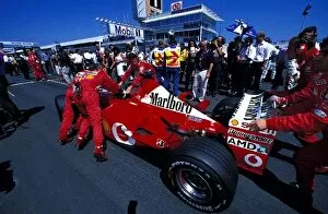 Images Dated 30th July 2002: Formula One World Championship: Ferrari mechanics push a Ferrari F2002 onto the grid