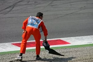 Images Dated 5th September 2005: Formula One World Championship: A marshal collects a bit of broken body work from the first chicane