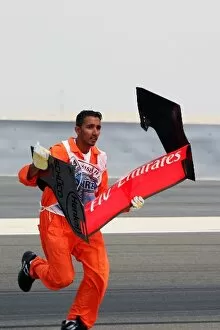 Images Dated 11th March 2006: Formula One World Championship: Mechanic recovers the rear wing of Kimi Raikkonen McLaren