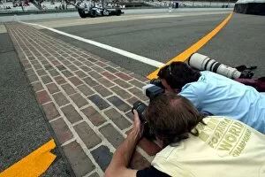 Images Dated 18th June 2004: Formula One World Championship: Photographers try and take pictures of the cars on the yard of