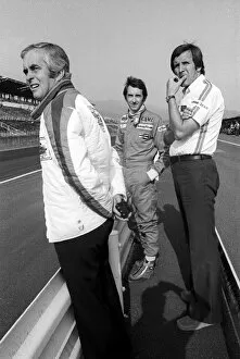 Formula One World Championship: Roger Penske Penske Team Owner stands on the pit wall with race retiree John Watson