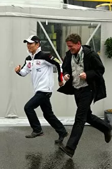 Images Dated 27th August 2004: Formula One World Championship: Takuma Sato BAR runs through the rain with his manager Andrew