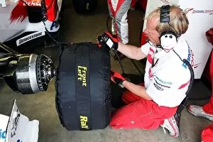 Images Dated 20th July 2007: Formula One World Championship: Toyota engineer waits to put a wet tyre on the Toyota TF107 of