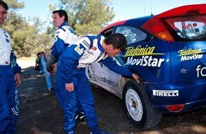 Cyprian Collection: World Rally Championship: Gilles Panizzi Peugeot examines the tyres of Markko Martins Ford Focus